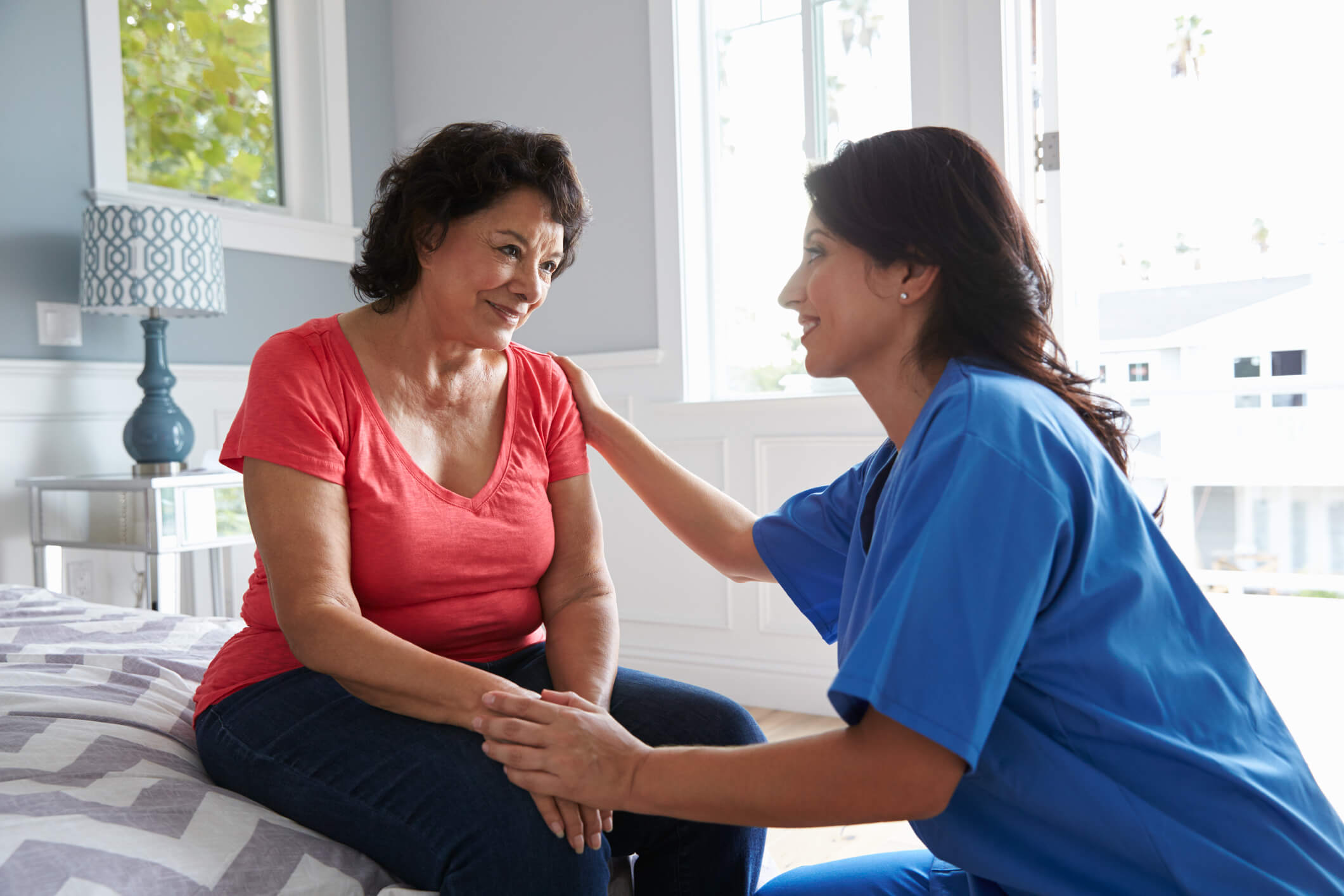 female licensed nurse helping older female patient