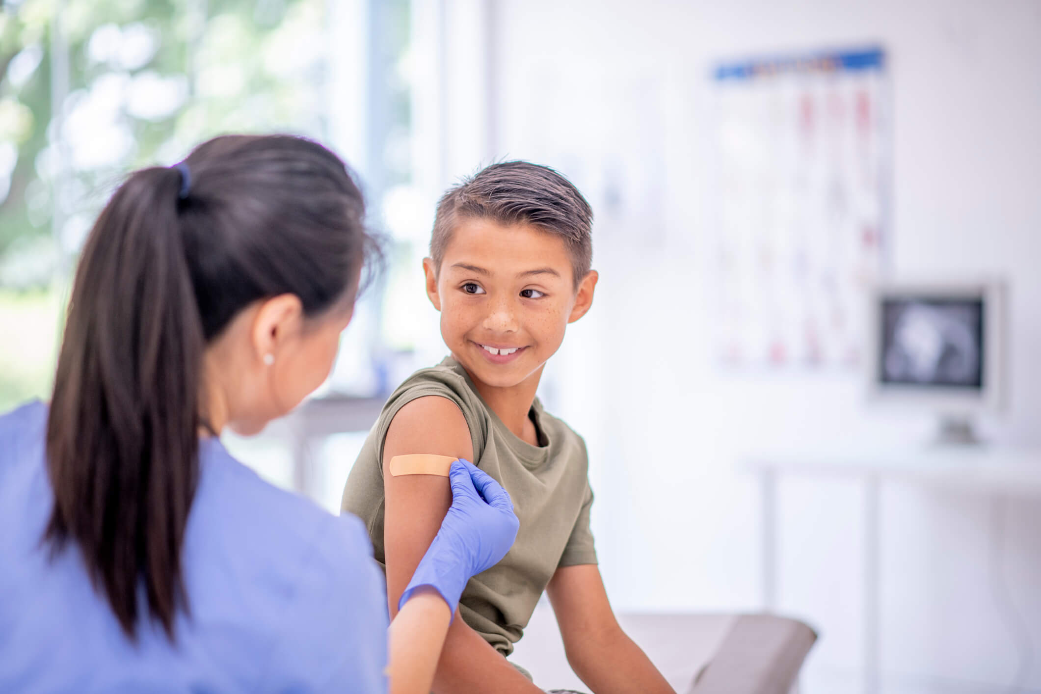 female nurse putting bandage on boy