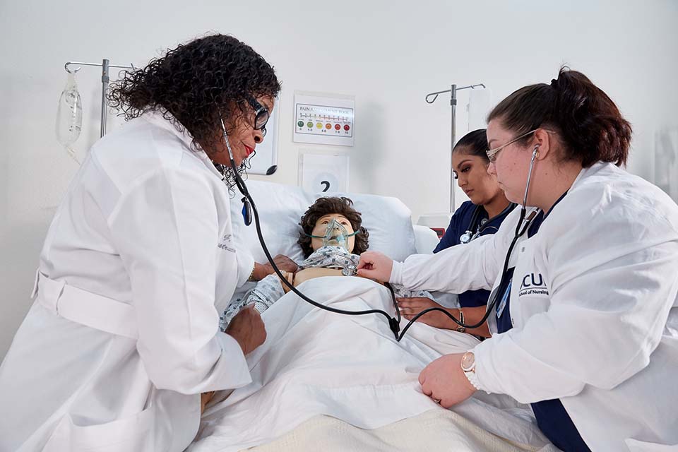 Smith Chason Instructor teaching students on a medical test dummy